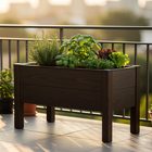 Kompaktes Balkon-Hochbeet aus Holz auf einem sonnigen Stadtbalkon